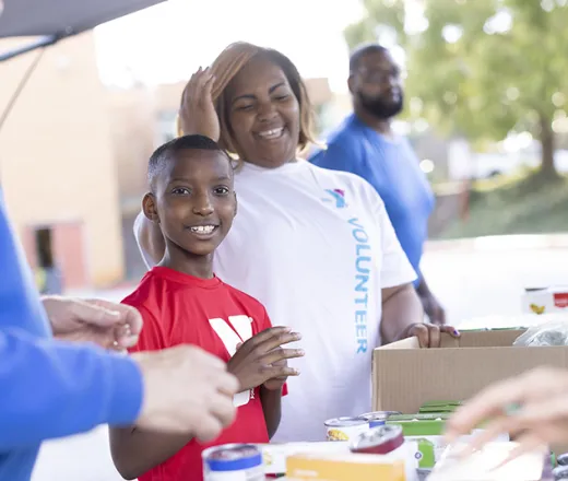 Young boy and his mom volunteering with food distribution
