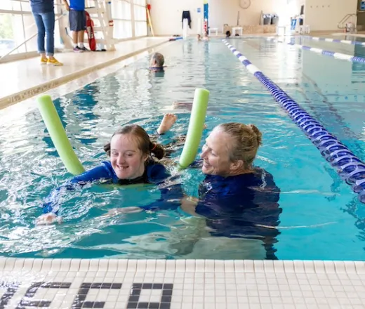 A person participating in an adaptive swim lesson in the pool